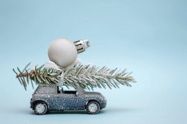 Christmas tree on a toy car on a blue background