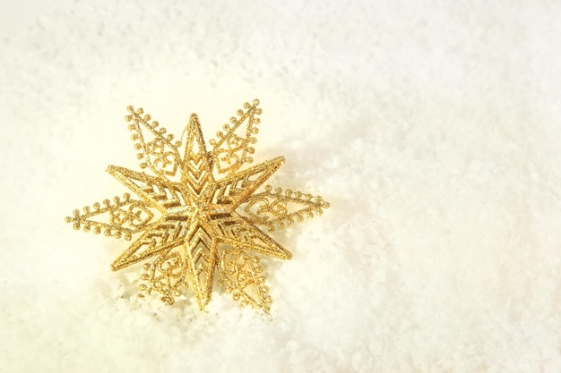 Christmas tree toy gold star on a snowy background Copy space bokeh