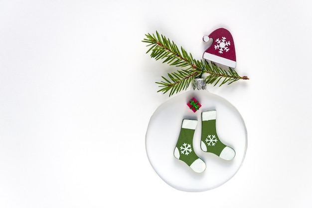 Christmas tree toy made of green socks and Santa Claus hat on white background