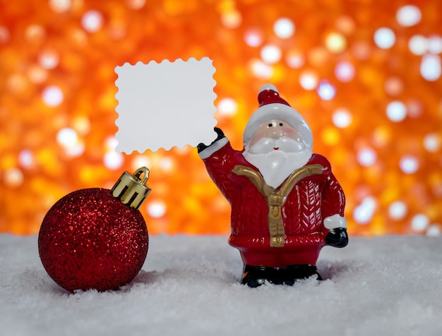 크리스마스 트리 장난감 산타클로스는 텍스트를 위한 공간이 있는 종이를 들고 있습니다. 크리스마스의 개념