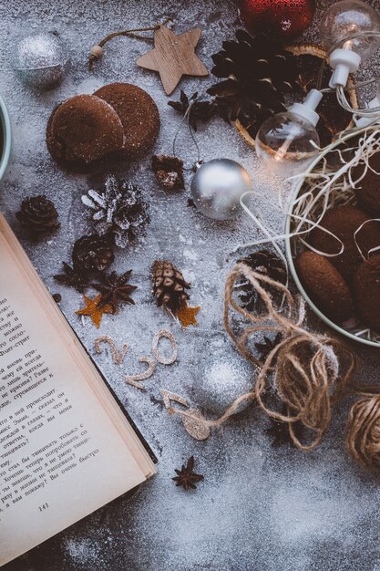 Christmas tree toys, pine cones and book in table. Number 2021