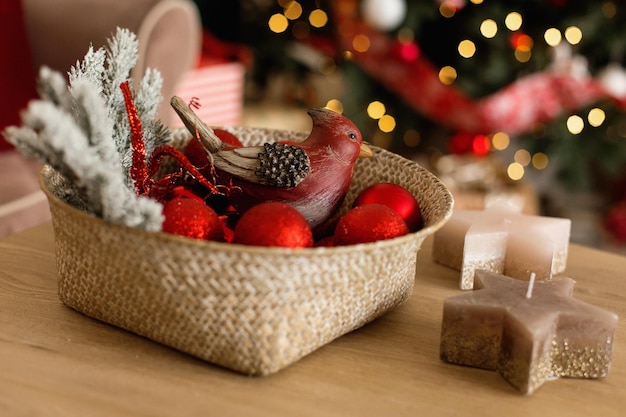 Photo christmas tree toys in a wicker basket on the background of the christmas tree christmas holidays