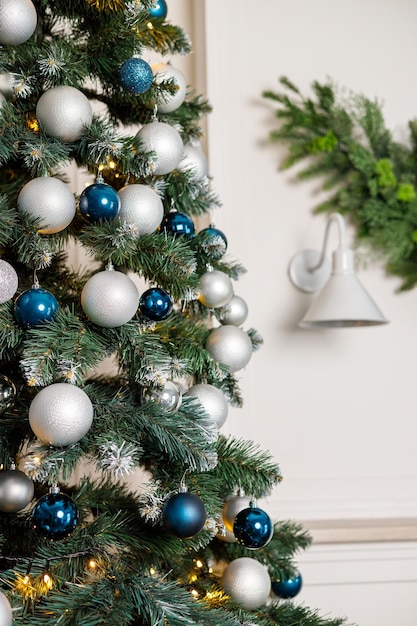 Christmas tree with blue and silver toys Festively decorated Christmas tree with garlands Symbol of the new year
