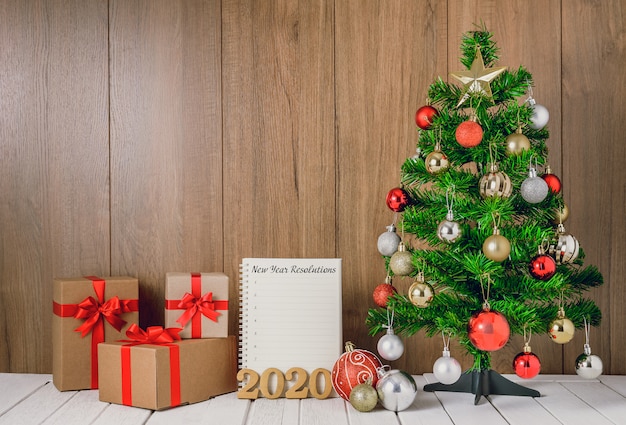 Albero di natale con palline colorate ornamenti e scatole regalo con il taccuino