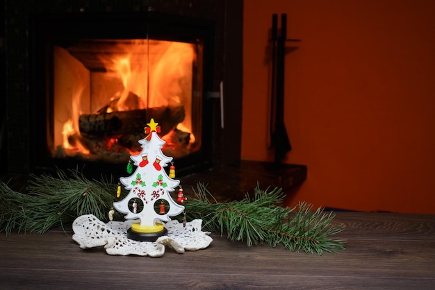 Albero di natale con coni dal caminetto acceso