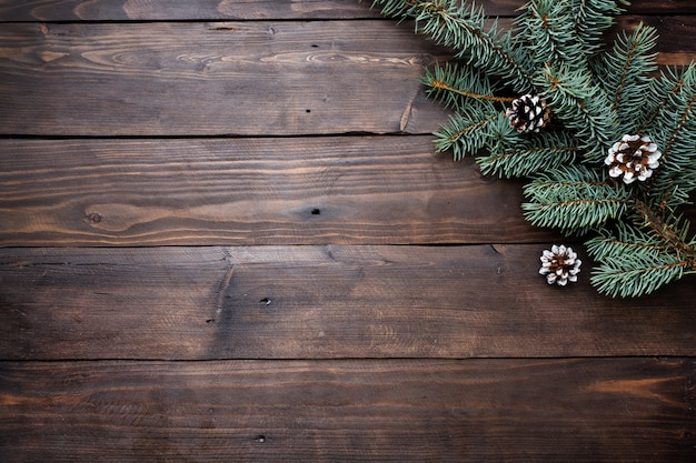 Christmas tree with cones on a dark wooden background. Copy space. Flat lay.