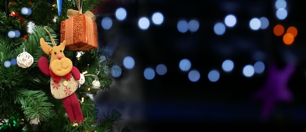 Рождественская елка с украшениями и подарком на размытом фоне