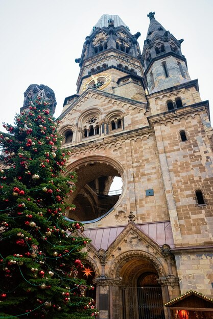 Christmas tree with decorations at Wilhelm Memorial Church on Christmas market in Berlin in Germany in Europe in winter. German street Xmas and holiday fair in European city or town.