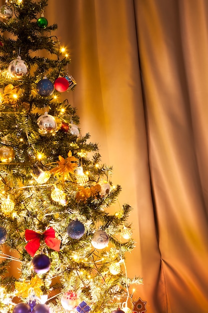 花輪と家の装飾が施されたクリスマスツリー。装飾的でお祝いの緑の木