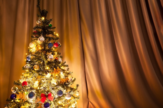 Albero di natale con ghirlande e decorazioni in casa. albero verde decorativo e festoso