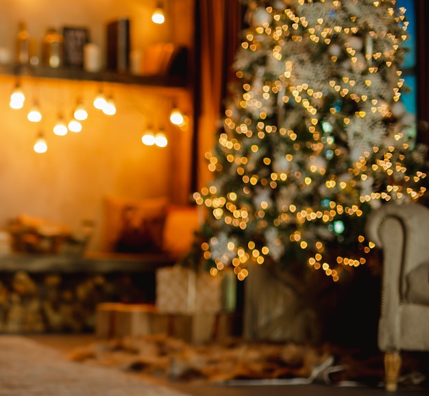 Christmas tree with gifts and reading corner decorated with garlands.