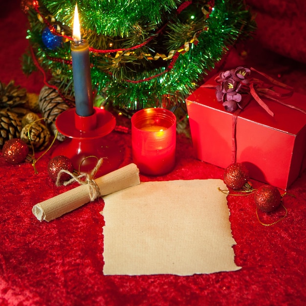 Foto albero di natale con carta e candela accesa