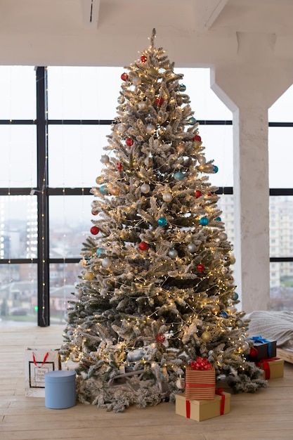 A christmas tree with a red and blue christmas tree and a red and gold christmas tree.