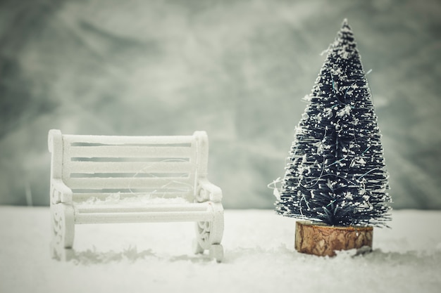 Christmas tree with a snow-covered bench. 