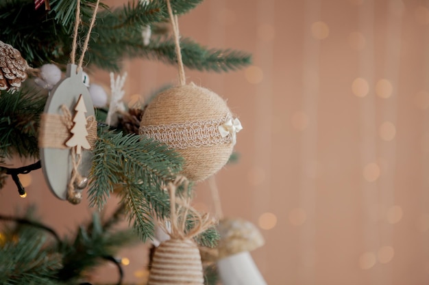 Albero di natale con giocattoli e neve decorativa per un felice anno nuovo su sfondo di bokee