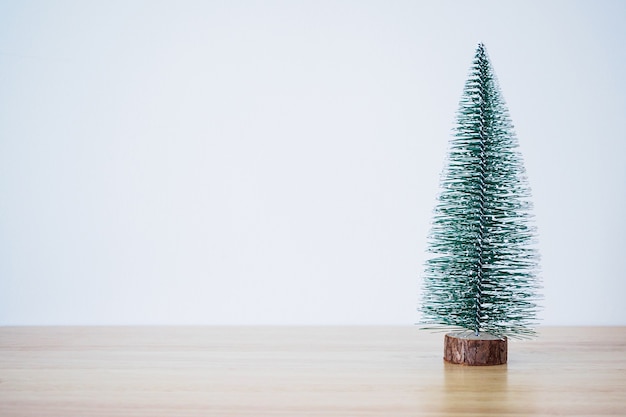 Christmas tree on wood table with white wall background