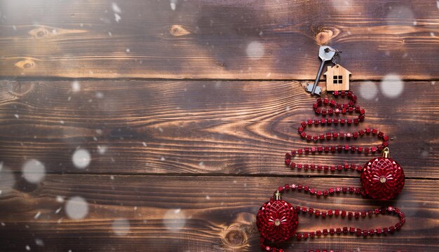 Foto albero di natale su sfondo di legno con chiave della casa e portachiavi con iscrizione in inglese