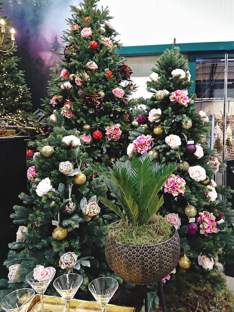 Alberi di natale decorati con ghirlande di fiori artificiali e palline di natale