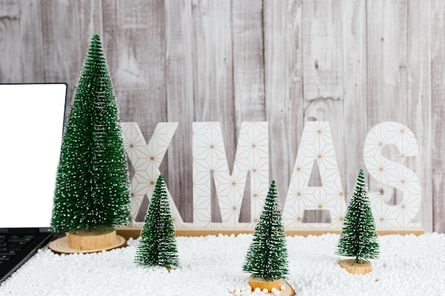 Christmas trees of different sizes and snow on a gray background