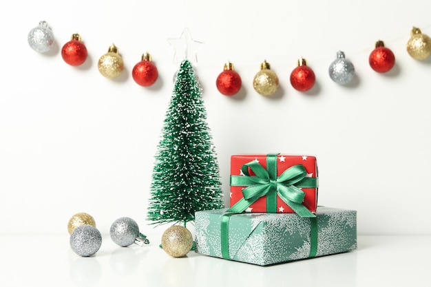 Christmas trees, gifts and baubles on white table