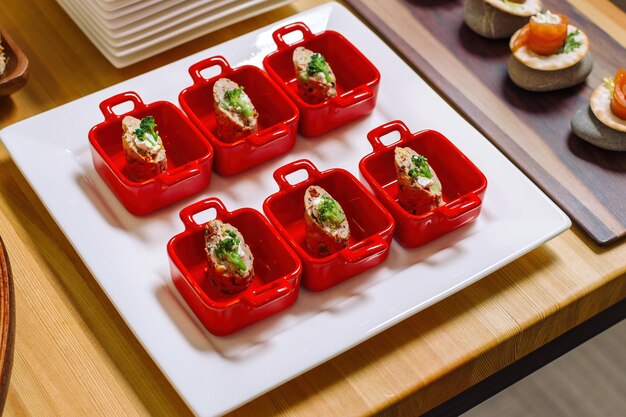 Rotolo di petto di tacchino di natale ripieno di formaggio e broccoli in bellissime ciotoline rosse di lusso
