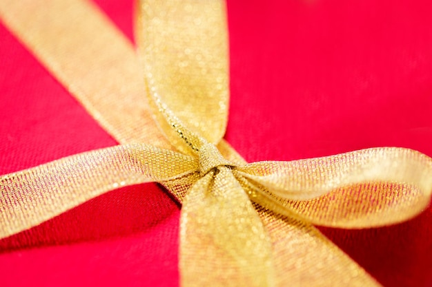 christmas, valentines day and holidays concept - close up of red gift box with golden ribbon bow