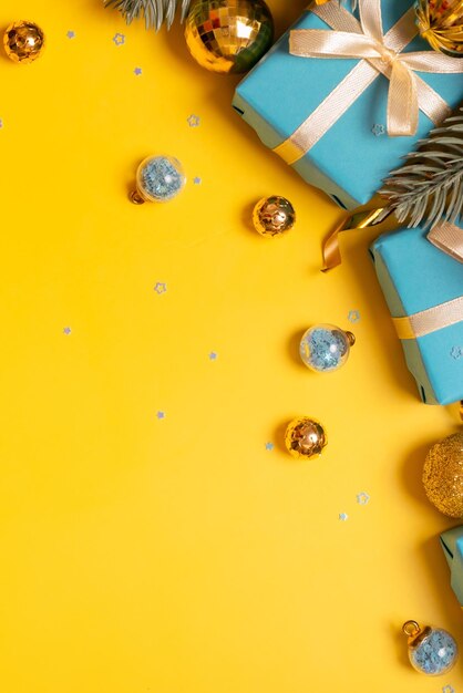 松の木の贈り物と色付きの背景のお祭りの装飾トップ ビューでクリスマス垂直グリーティング カード