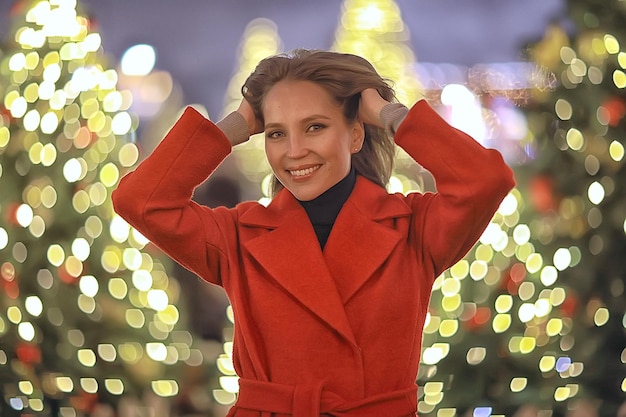 街のクリスマス散歩/お祭りの夜に夜の街を歩く大人の女の子、街の明かりは新年です