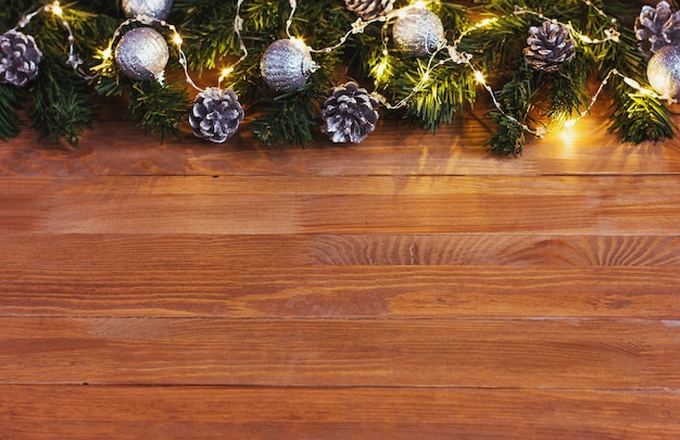 Christmas wall Christmas tree decorated with a garland of lights on a wooden table copy spase