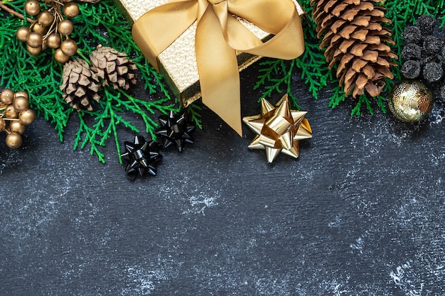 Christmas wenskaart concept met fir tree takken en gouden decoraties op zwarte achtergrond