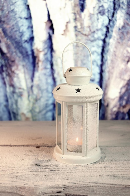 Christmas, white lantern with a burning candle, on a wooden table, Christmas decorations