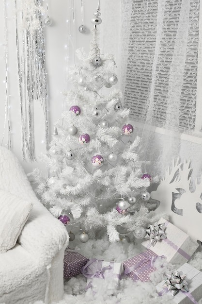 Christmas white tree with ball toys and gift box presents underneath