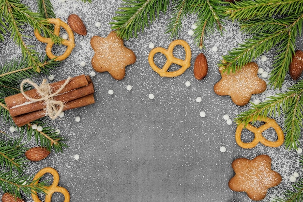 Christmas winter background Spicy ginger cookies pretzels flour Copy space Slate and snow Fir twigs