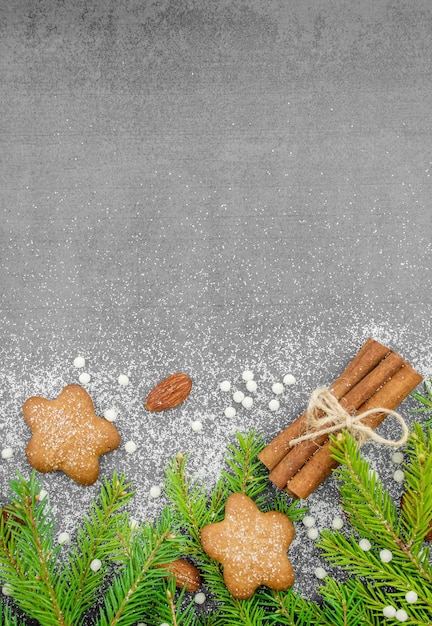 Christmas winter background Spicy ginger cookies pretzels flour Copy space Slate and snow Fir twigs