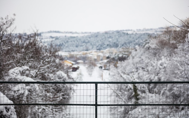 クリスマス冬のコンセプト 村と自然の雪に覆われた遠くのぼかしビュー