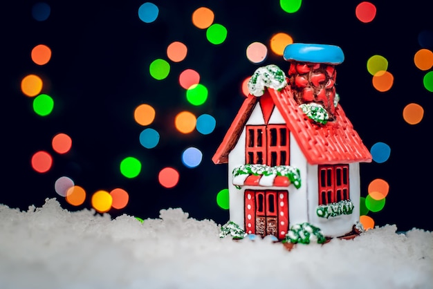 La notte invernale di natale è una foto con la casa con il tetto rosso sullo sfondo di luci colorate bokeh