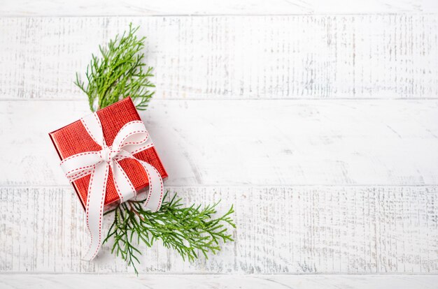 白い木製の背景に赤いギフトボックスとクリスマス。冬のお祝い。トップビュー、フラットレイアウト、copyspace。