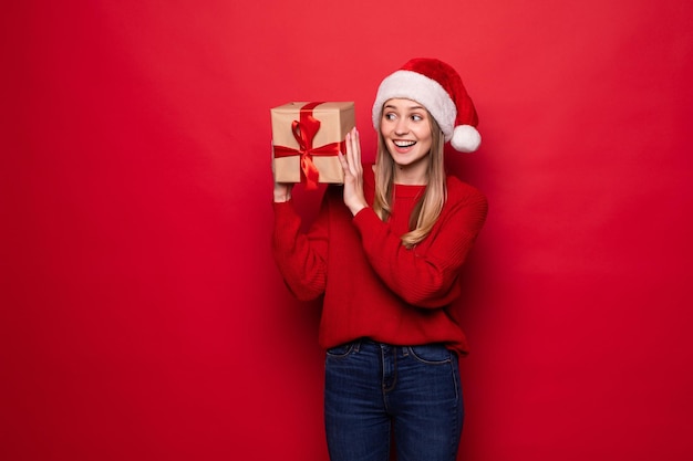 笑顔のクリスマスプレゼントを持っているクリスマスの女性