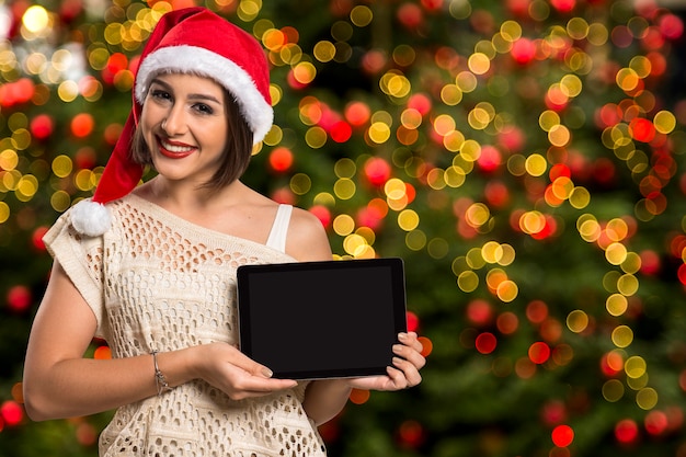 크리스마스 여자 초상화 지주 태블릿입니다. 크리스마스 bokeh 빛에 웃는 행복 한 여자