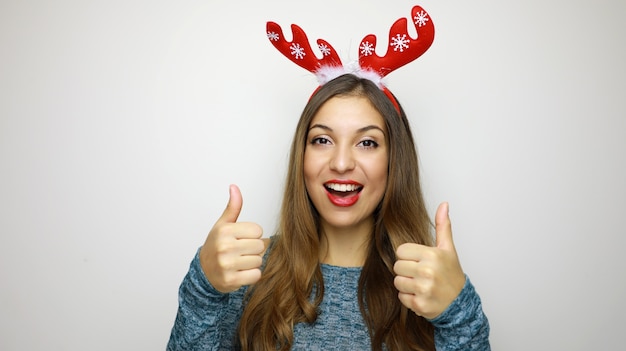 Christmas woman wearing reindeer horns giving thumbs up