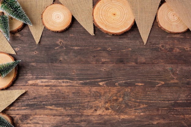 Christmas wood log plate and kraft flag and xmas tree on brown wooden table