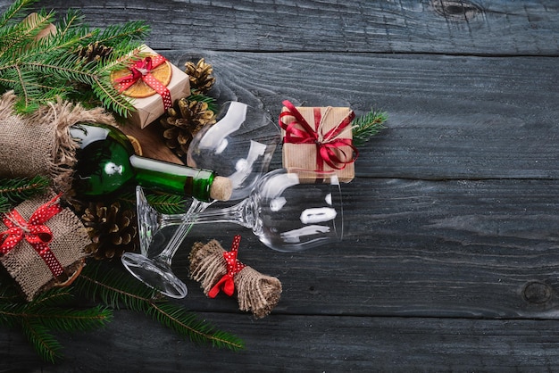 Christmas wooden background. A bottle of wine. New Year's holiday. Christmas motive. On a wooden surface. Top view. Free space for your text.