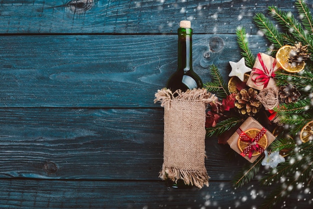 Photo christmas wooden background a bottle of wine new years holiday christmas motive on a wooden surface top view free space for your text