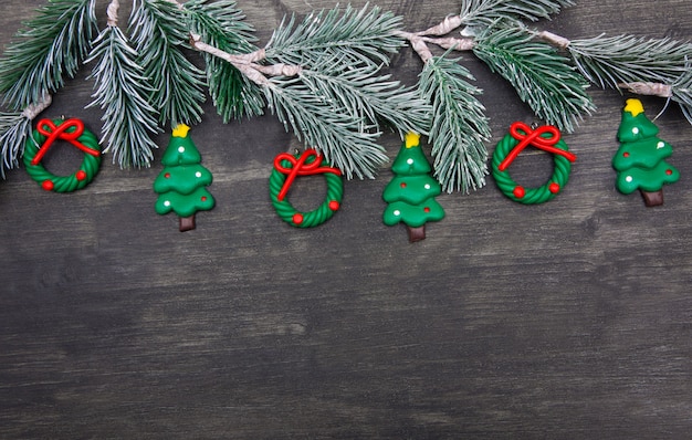 Sfondo di natale in legno con albero di natale e decorazioni rosse.