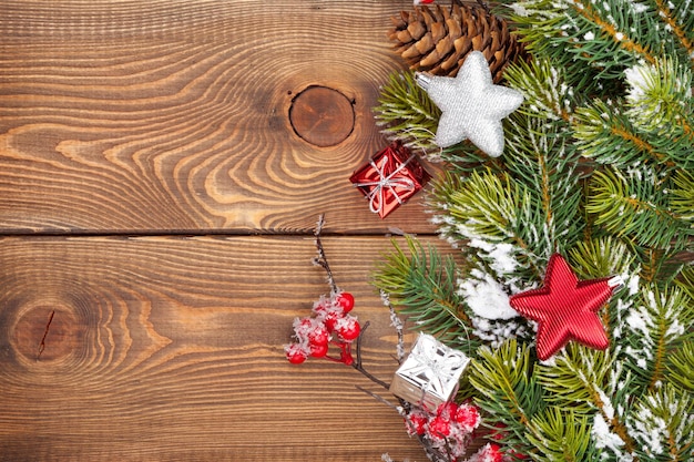 Christmas wooden background with snow fir tree and decor