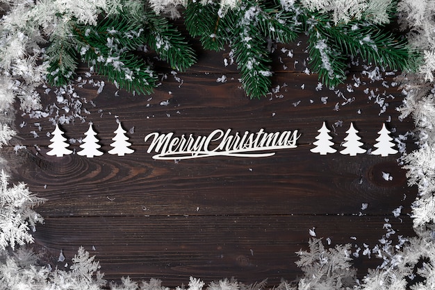 Christmas wooden background with snow fir tree.