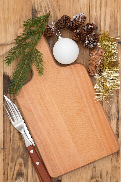 Photo christmas wooden board with knife on brown wood