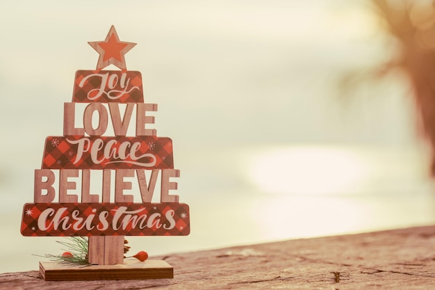 Photo christmas wooden toy tree on the beach