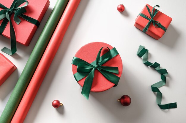 Рождественские подарки упаковки с красным и зеленым украшением на сером.