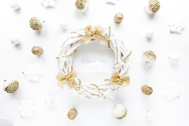 Рамка рождественского венка из цветных ярко-золотых елочных шаров на белом фоне плоско лежала